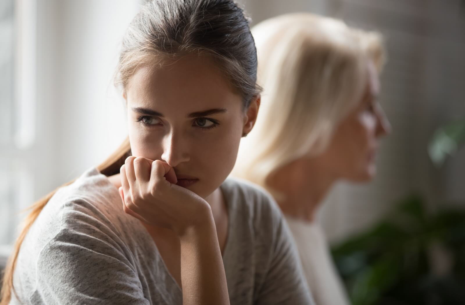 A woman with an annoyed look facing away from her older adult mother.