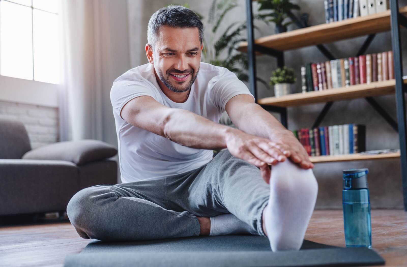 A man stretching early in the morning as a part of his self-care routine.
