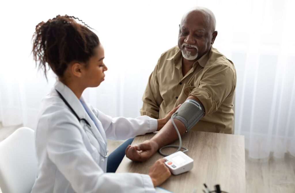 Healthcare professional checking the blood pressure of an older adult during a health screening.