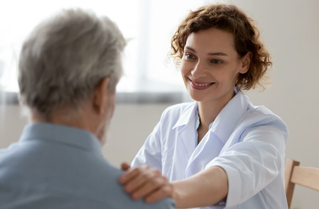 A caregiver in assisted living smiling and reassuring a new community member about safety measures to reduce the risk of falls.