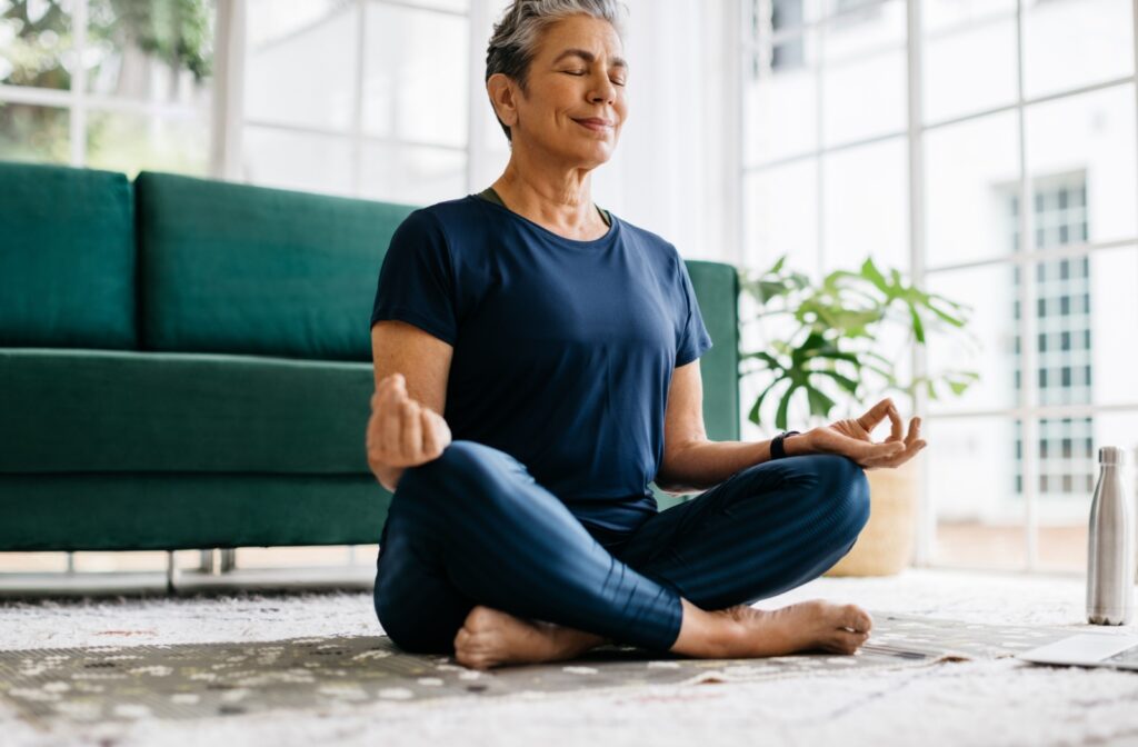 An older adult meditating after a yoga class in assisted living.